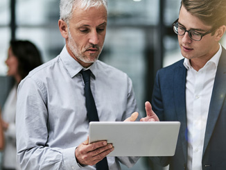 Two business colleagues reviewing content on an ipad